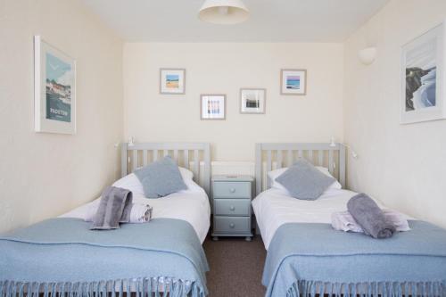 two twin beds in a room with white walls at The Barn, St Minver in Wadebridge