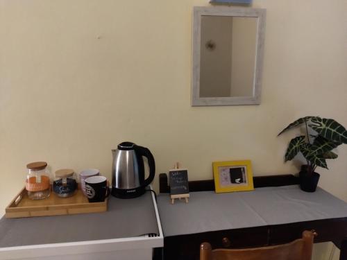 a counter top with a coffee pot and a mirror at Jimmy's Apartments in Moraitika