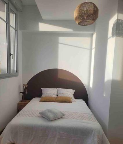 - un lit avec 2 oreillers dans une chambre dans l'établissement Résidence des Berges de l’Aisne, à Soissons