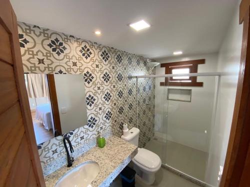 a bathroom with a toilet and a sink and a shower at Apartamentos da Rota 2 in Domingos Martins
