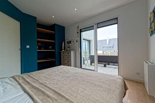 a bedroom with a large bed and a large window at Ty Loum classé 4 étoiles in Ploubazlanec