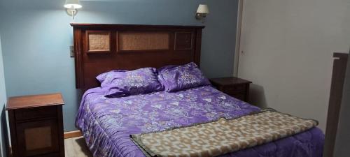 a bed with a purple comforter in a bedroom at Borde Mar Costa Papudo in Papudo