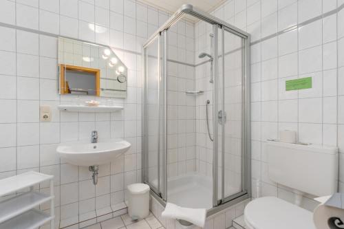 baño blanco con ducha y lavamanos en BmB Vollersode Monteurzimmer / Pension, en Vollersode