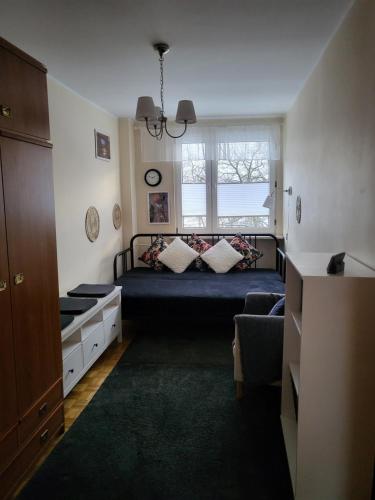 sypialnia z łóżkiem z oknem i kanapą w obiekcie Przytulne mieszkanie Wola Duchacka w Krakowie