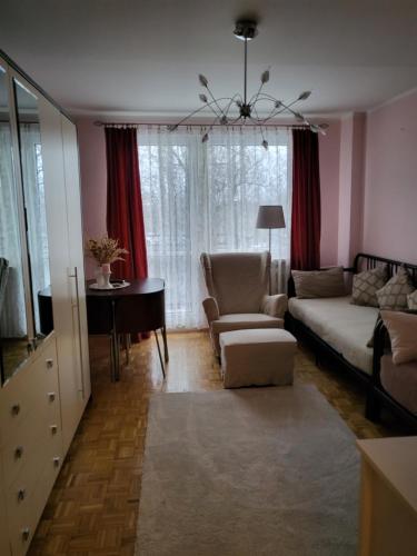 a living room with a couch and a chair at Przytulne mieszkanie Wola Duchacka in Kraków