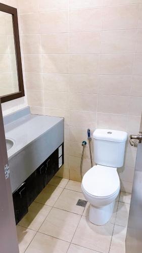 La salle de bains est pourvue de toilettes blanches et d'un lavabo. dans l'établissement Cozy Stay at Shaftsbury Residences by SNS HOMES, à Cyberjaya