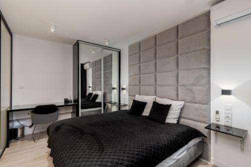 sypialnia z dużym czarnym łóżkiem i lustrem w obiekcie Diamonds Apartment w Krakowie