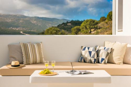 a living room with a couch and glasses of wine at Kefalonia Grande Horizon in Ayia Evfimia
