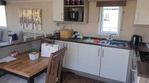 a kitchen with a wooden table and a sink at Swift Moselle in Lincolnshire
