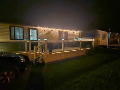 Lincolnshire的住宿－Swift Moselle，夜晚,房子的一侧有灯