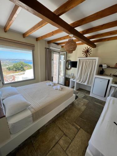 a bedroom with a large bed and a large window at Villa Mina in Adamantas