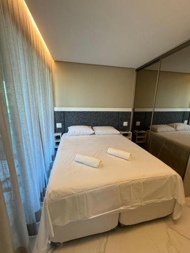 sypialnia z 2 łóżkami i dużym lustrem w obiekcie Flat+deck ao lado da igrejinha w mieście Praia dos Carneiros