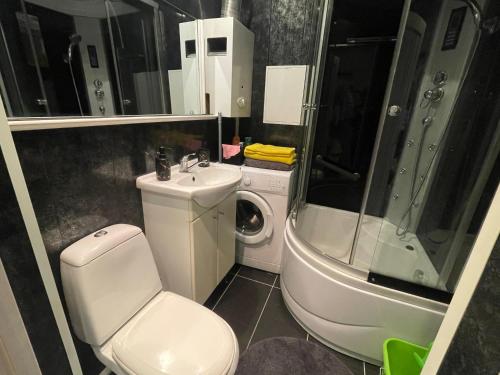 a bathroom with a toilet and a sink and a shower at Vironia Apart in Kohtla-Järve