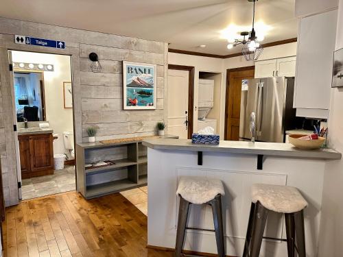 a kitchen with a counter and two stools in it at L'Algonquin by Tremblant Vacations in Mont-Tremblant