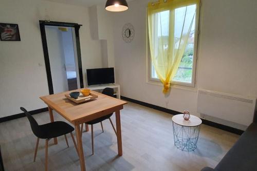 un salon avec une table et des chaises et une fenêtre dans l'établissement *L'Anatole*/Haute Ville/TULLE, à Tulle