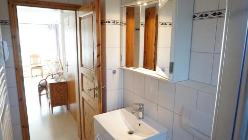 La salle de bains est pourvue d'un lavabo et d'un miroir. dans l'établissement Ankerplatz, à Garding