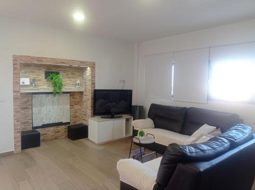 a living room with a couch and a tv at Alojamiento de Jorge in Herencia