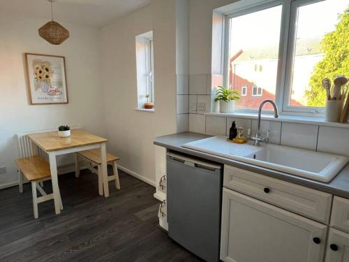 a kitchen with a sink and a table and a window at Entire cosy home in Liverpool Marina in Liverpool
