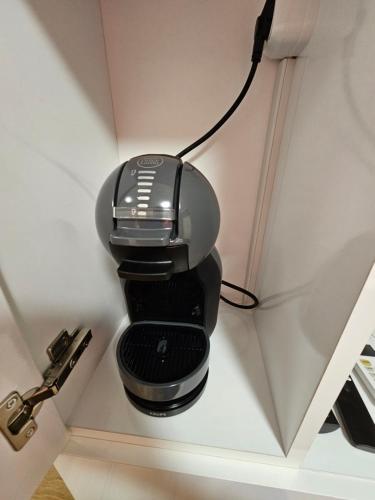 a black coffee maker hanging on a wall at STUDIO 7 in Veliko Tŭrnovo