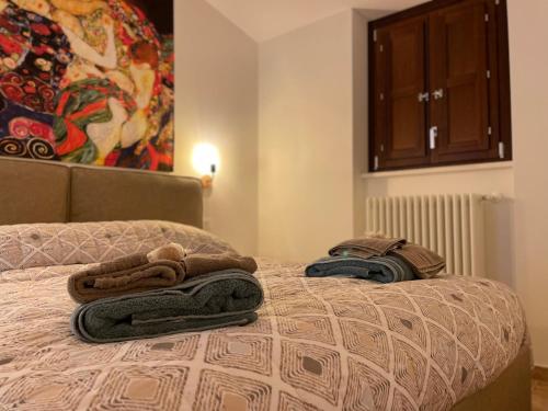 a bedroom with a bed with towels on it at Le Finestre sul Duomo in LʼAquila