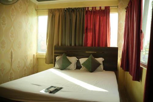 a bedroom with a large bed with a window at HOTEL AIRPORT HEAVEN in kolkata