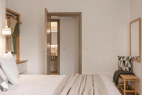 a bedroom with a bed and a mirror and a chair at Kefalonia Grande Horizon in Ayia Evfimia