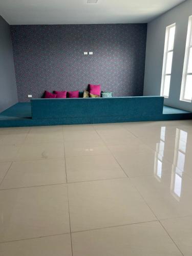 a waiting room with a blue bench with pink pillows at Hotel Suites Lounge La Viga in Cali
