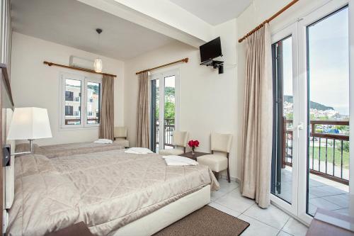 a bedroom with a large bed and a balcony at Akti Fine Rooms in Skopelos Town