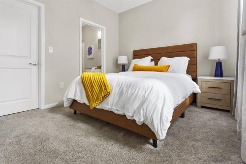 um quarto com uma cama grande com almofadas brancas e amarelas em Oxford - The Oxford House em Oxford