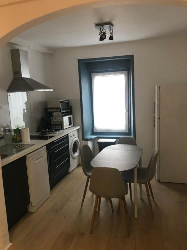 - une cuisine avec une table et des chaises dans la chambre dans l'établissement Joli appartement calme à Binic dans rue piétonne, à Binic