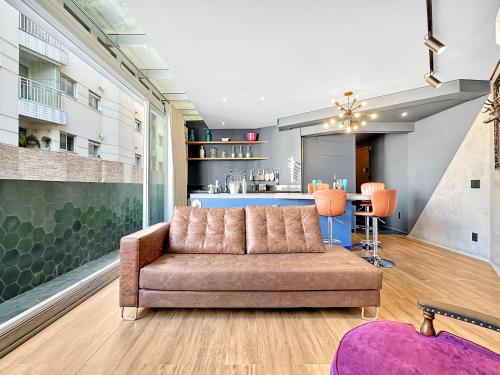 a living room with a couch and a kitchen at Lindo apartamento ao lado Shop Frei Caneca e do Parque Augusta in Sao Paulo