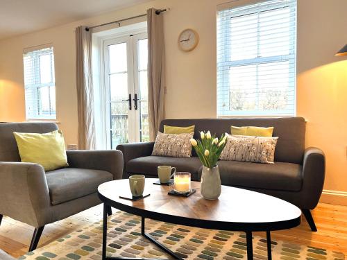 a living room with a couch and a coffee table at Cosy Cotswold Home - Jacobs Cottage in Cirencester