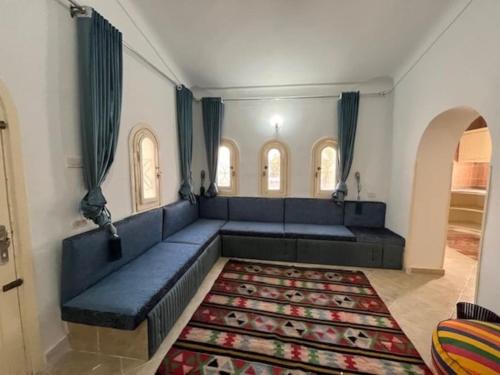 Prime location family beach villa - 16 pax في الإسكندرية: غرفة معيشة مع أريكة زرقاء وسجادة