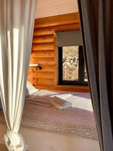 a bedroom with a bed and a window at Private Mountain Log Cabin with amazing panoramic sunset views at small scale nature resort in Cabeceiras de Basto