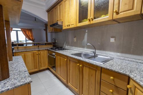 a kitchen with wooden cabinets and a sink at Blue Sky Apartments-Ulcinj, Montenegro in Ulcinj