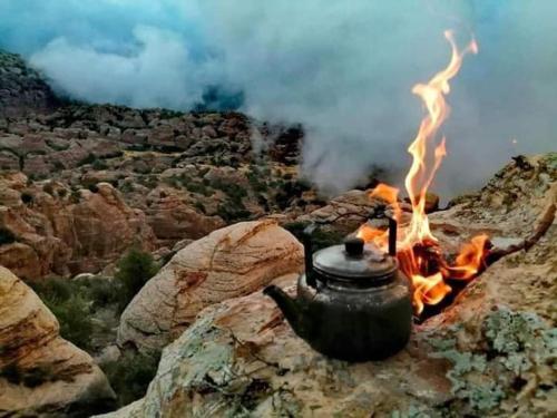 a tea pot on a rock with a fire at Dana Nabil Ecu Camp House - Main Gate Dana nature reserve in Dana