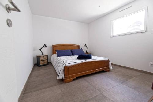 a bedroom with a bed with blue pillows and a window at La terrasse du Porjou classée 3 étoiles in Ploubazlanec