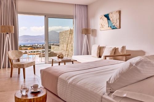 a hotel room with a bed and a large window at Civitas Milos in Adamas