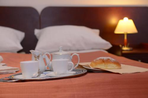 a table with two cups of tea and a pastry on it at Hotel Pod Dębami in Terespol