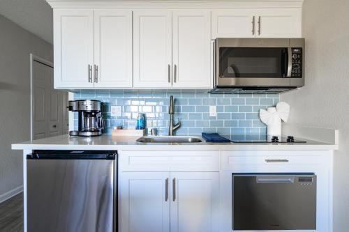 a kitchen with white cabinets and a sink and a microwave at Spectacular Ocean View - 3 Heated Pools - Seascape in Aptos