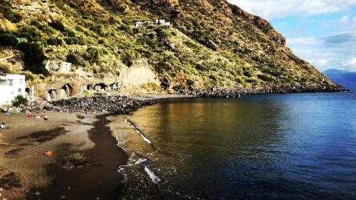 a beach next to the water with a mountain at Casa del Geco in Rinella
