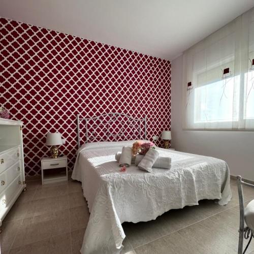 - une chambre avec un lit et un mur rouge dans l'établissement Casa Balcon del Mar, à Calafell