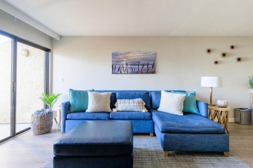 a living room with a blue couch and a table at Spectacular Ocean View - 3 Heated Pools - Seascape in Aptos