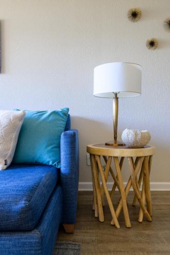 a lamp on a table next to a blue couch at Spectacular Ocean View -Heated Pool and Spa- Seascape in Aptos