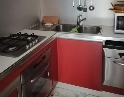 una cocina con armarios rojos y fregadero en La Palma, en Viareggio