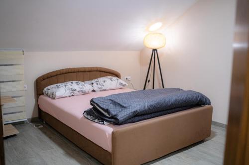 a bedroom with a bed with a lamp on it at Big Lale UR in Bijeljina