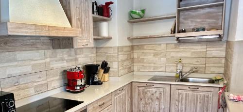 a kitchen with wooden cabinets and a sink at Chalet Paradisi in Castello Tesino