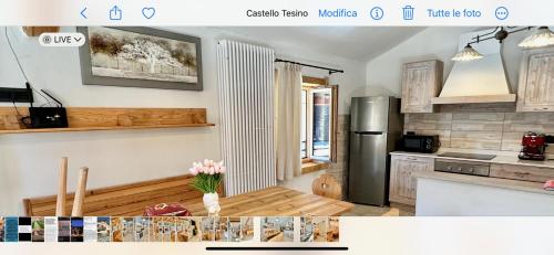 a kitchen with a refrigerator and a table in it at Chalet Paradisi in Castello Tesino