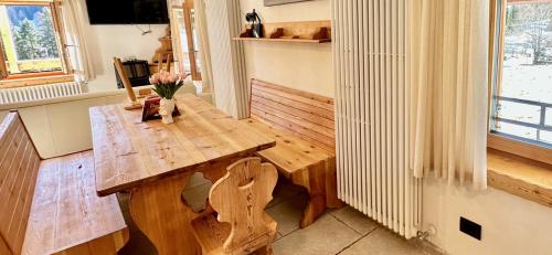 a wooden table in a room with a vase of flowers at Chalet Paradisi in Castello Tesino