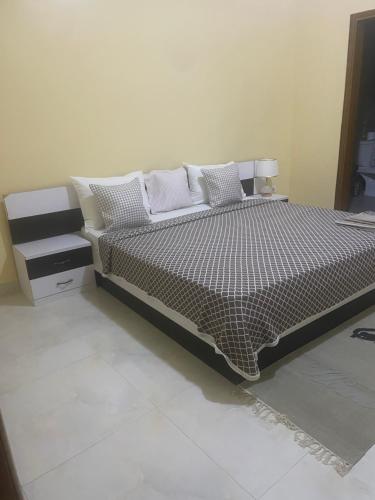 a bedroom with a bed with a black and white comforter at Reema B&B in Dakar